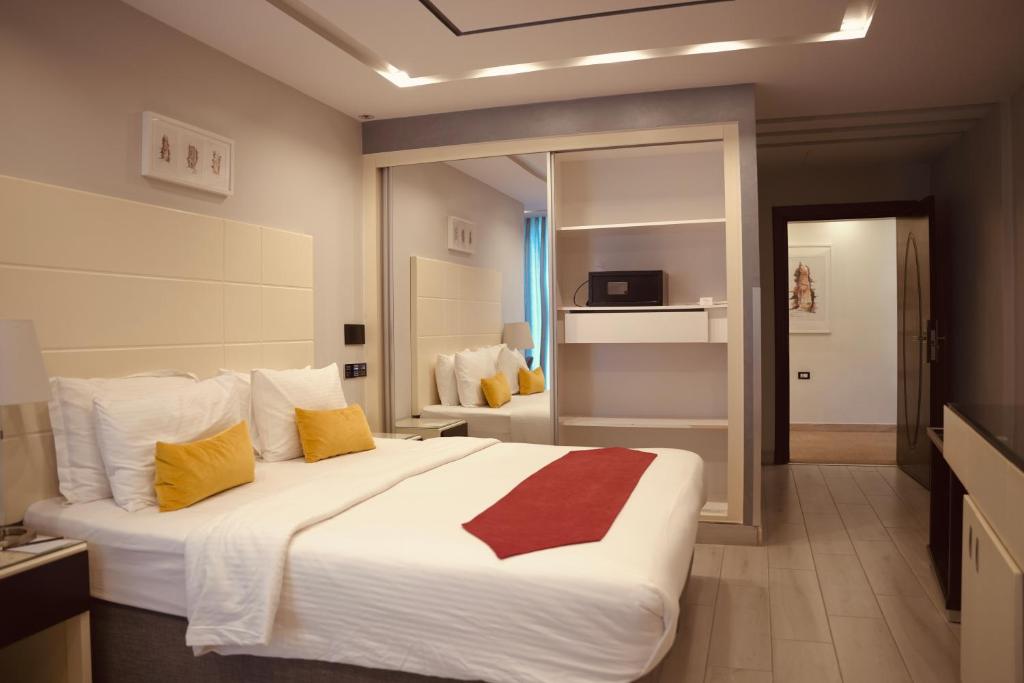 瓦迪穆萨Petra Boutique Hotel的一间卧室配有一张大床,提供黄色和红色枕头