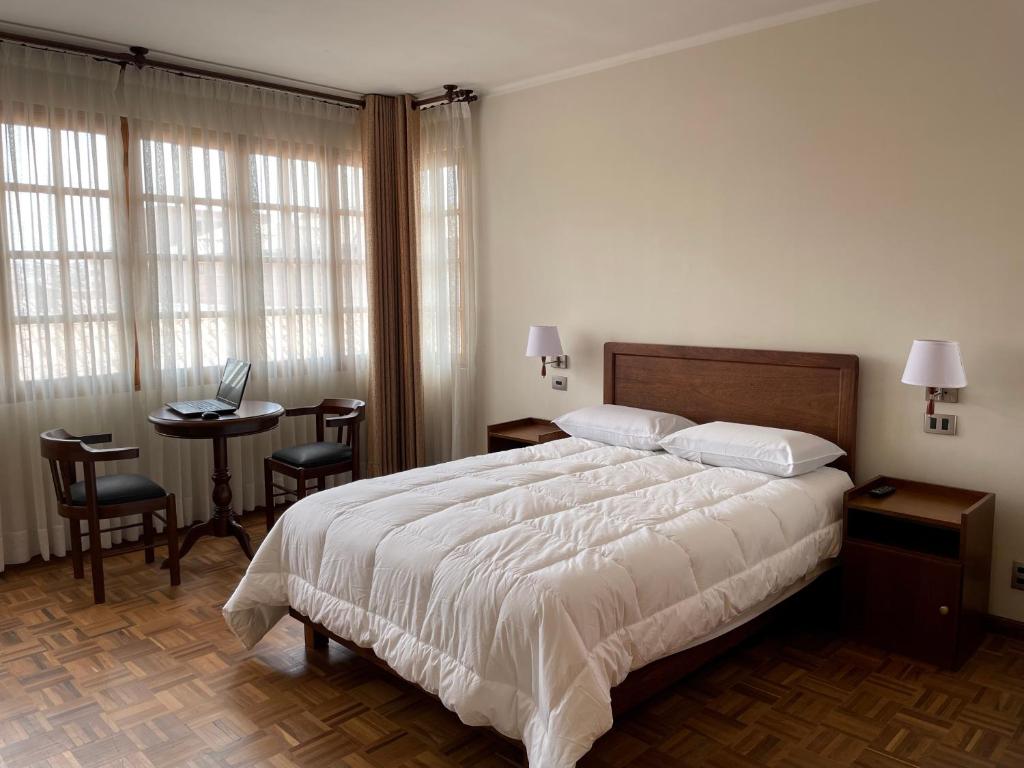 苏克雷HOSPEDAJE SARABIA的一间卧室配有一张床和一张带笔记本电脑的桌子