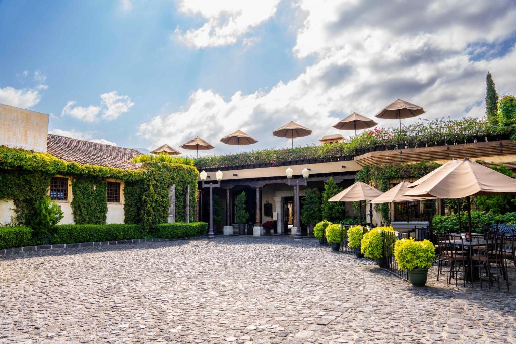 危地马拉安地瓜安提瓜卡米诺雷亚度假酒店的庭院配有遮阳伞和桌椅。