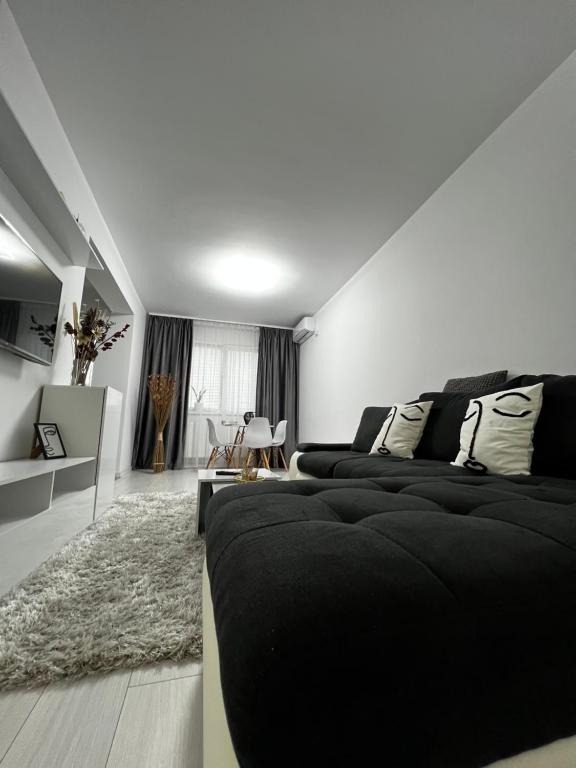 Popeşti-LeordeniNew Residence Apartament的一间带黑色床的卧室和一间客厅