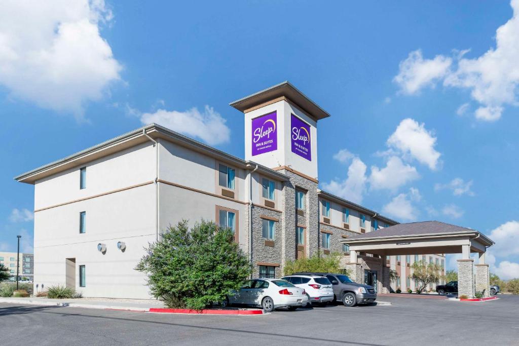 卡尔斯巴德Sleep Inn & Suites Carlsbad Caverns Area的停车场内有车辆的旅馆