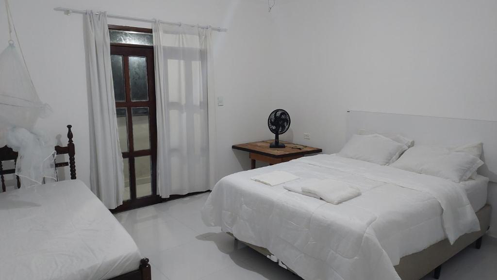 伊比科阿拉Residencial Maria de Lourdes的白色的卧室设有床和窗户