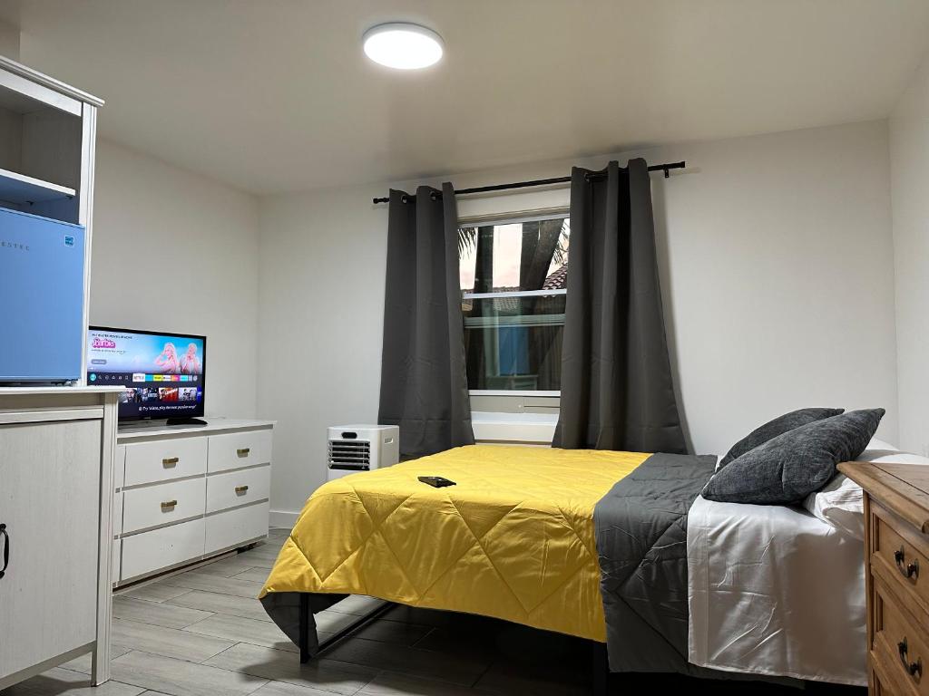 迈阿密SERENE FULL BED NEAR DOLPHIN MALL/FIU的一间卧室配有黄色的床和电视
