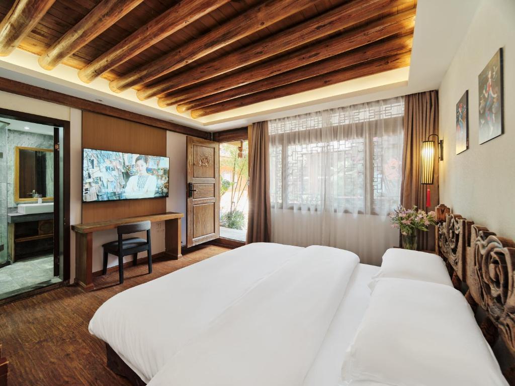 丽江丽江夕露小榭客栈的一间卧室配有两张床和一台平面电视