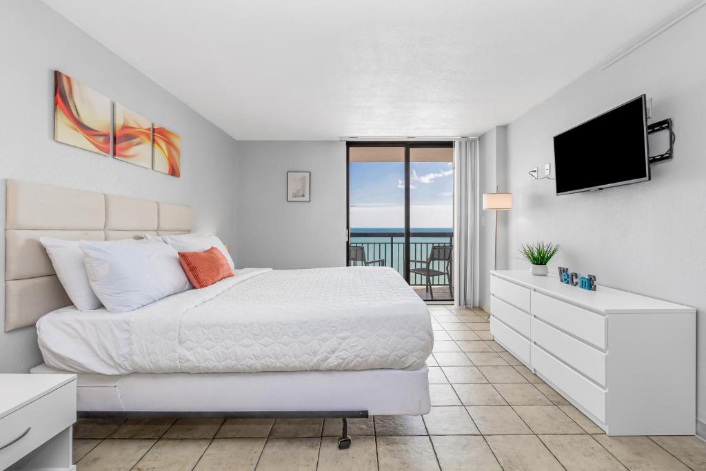 默特尔比奇Romantic Oceanfront Studio Escape w Perfect View 1212的白色卧室配有床和平面电视