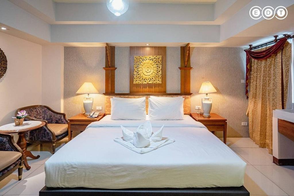 曼谷Kim Hotel At Morleng的酒店客房,配有一张大床和两把椅子