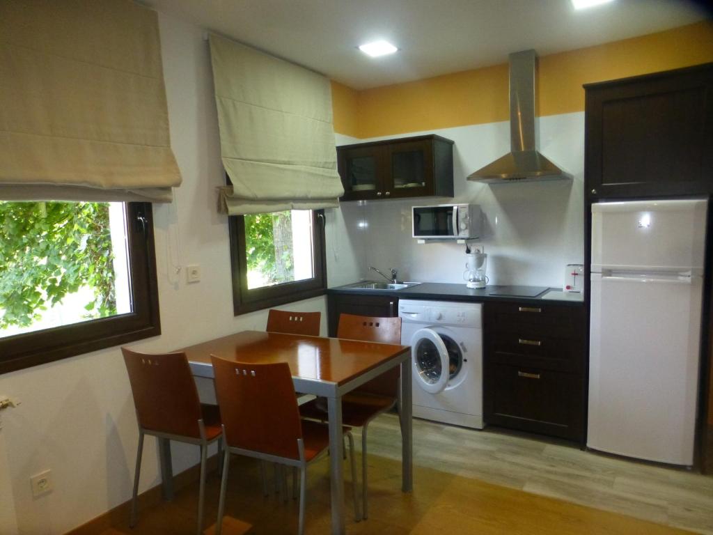 里瓦德塞利亚La Casina de Torra的厨房配有桌椅和冰箱。