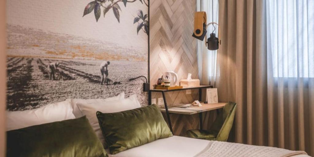 赖维拉维基布兹酒店的配有一张床和一张书桌的酒店客房
