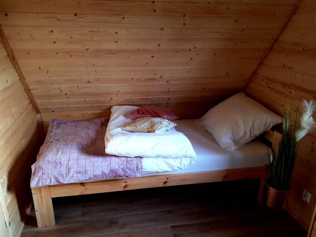 米奇科夫采Domki OstoYa Bieszczady/Solina的小屋内木制房间的一个床位