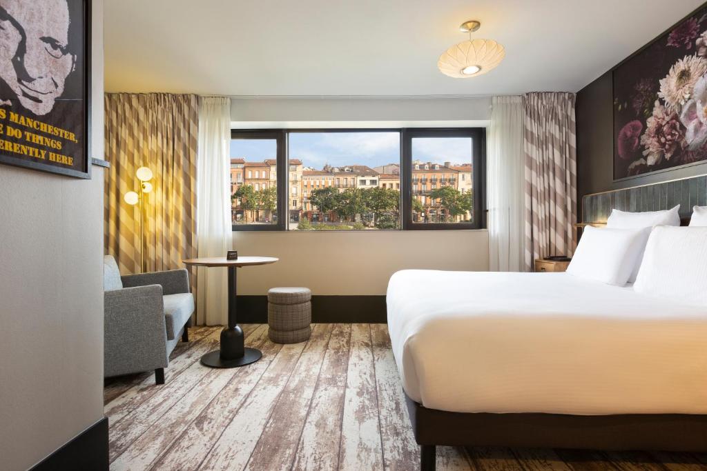 图卢兹Hotel Les Capitouls Toulouse Centre - Handwritten Collection的酒店客房设有床和窗户。