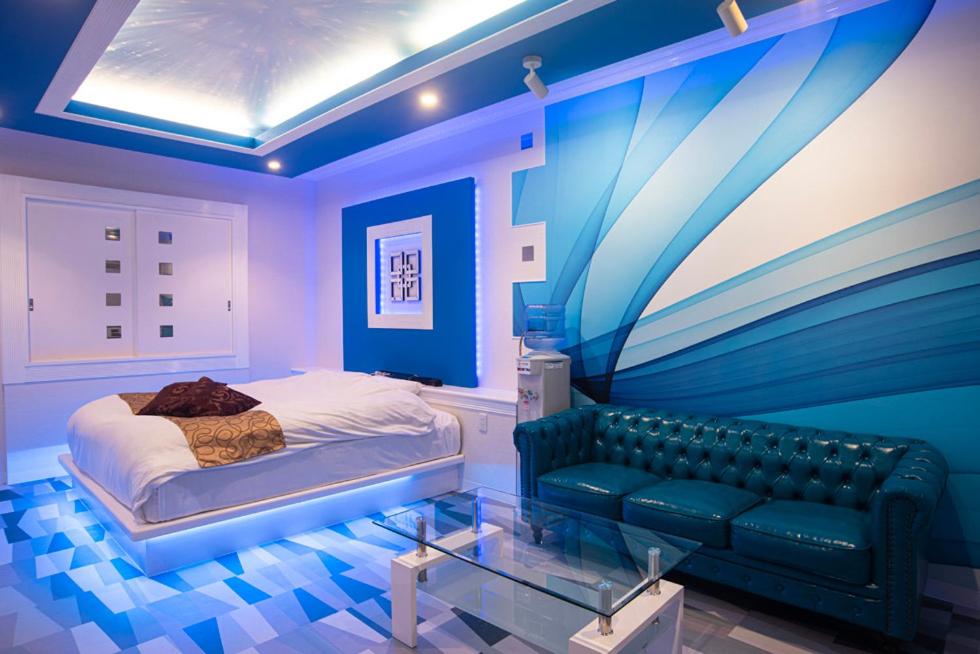 郡山Hotel Bypass (Adult Only)的蓝色的卧室配有床和沙发