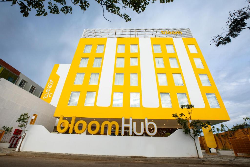 班加罗尔Bloom Hub - ORR Marathahalli的黄色和白色的建筑,上面有标志
