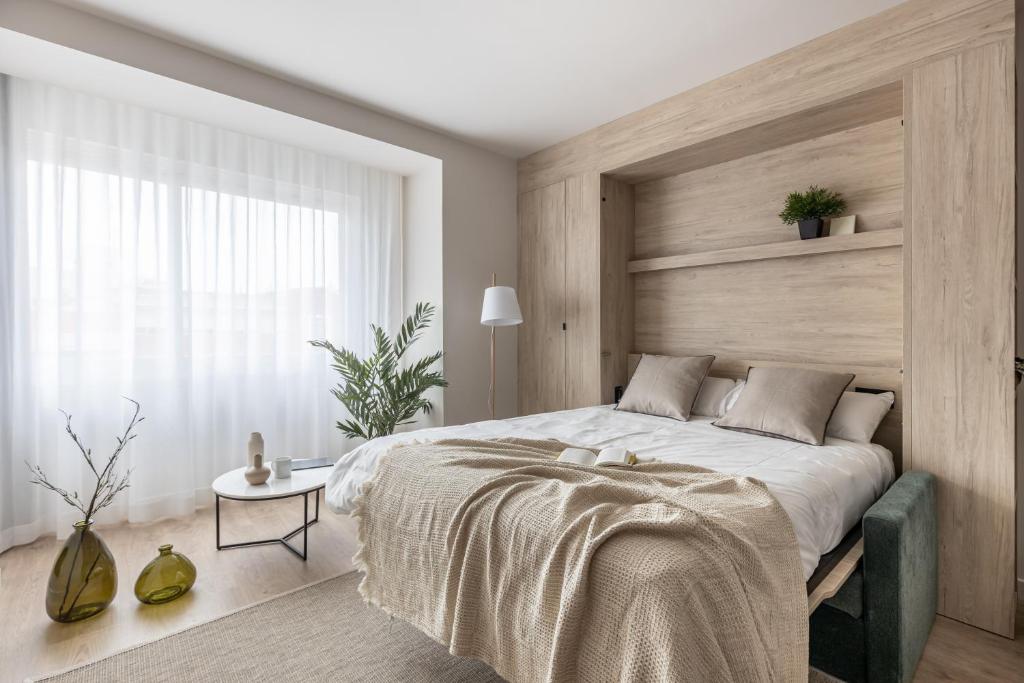 马德里Líbere Madrid Chamberí的一间卧室配有一张大床和木制床头板