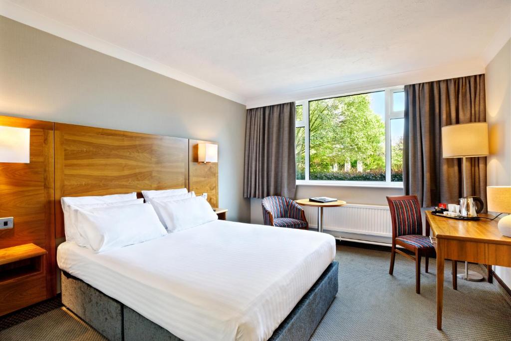 哈德斯菲尔德Cedar Court Hotel Huddersfield的酒店客房设有一张大床和一张书桌。