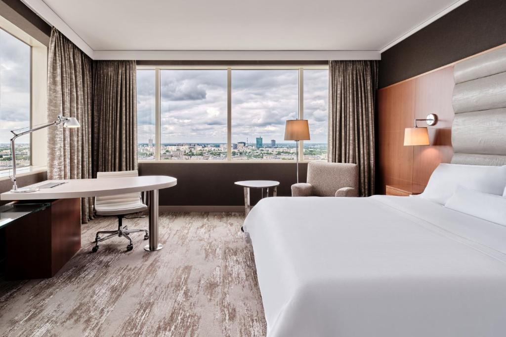 华沙华沙威斯汀酒店的配有一张床、一张书桌和一扇窗户的酒店客房