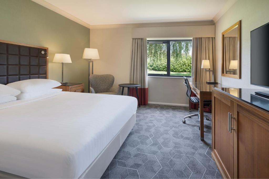 彼得伯勒Delta Hotels by Marriott Peterborough的酒店客房设有一张大床和一台电视。