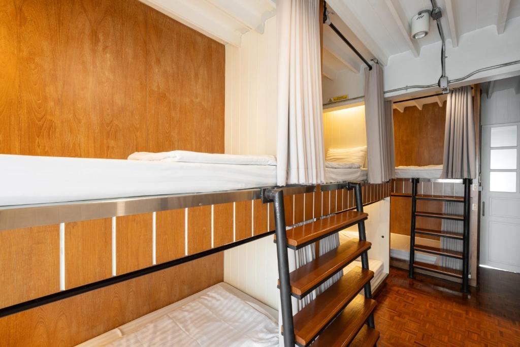 清迈Bed Addict Hostel的带两张双层床和楼梯的客房