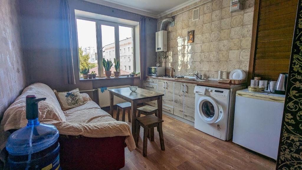 切尔尼戈夫Двухкомнатная Квартира на Пятницкой的厨房配有洗衣机和桌子