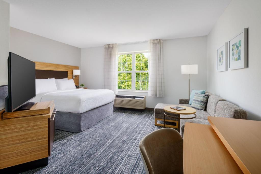曼切斯特曼切斯特波士顿地区机场广场套房酒店的酒店客房,配有床和沙发