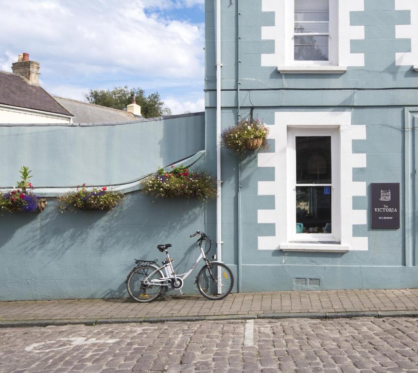 奥尔德尼The Victoria的停在蓝色建筑旁边的自行车