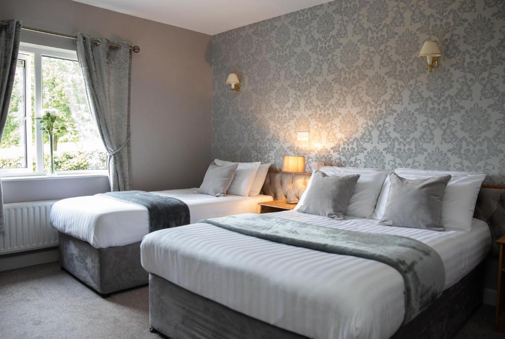 莫纳汉Sliabh Beagh Hotel的酒店客房设有两张床和窗户。