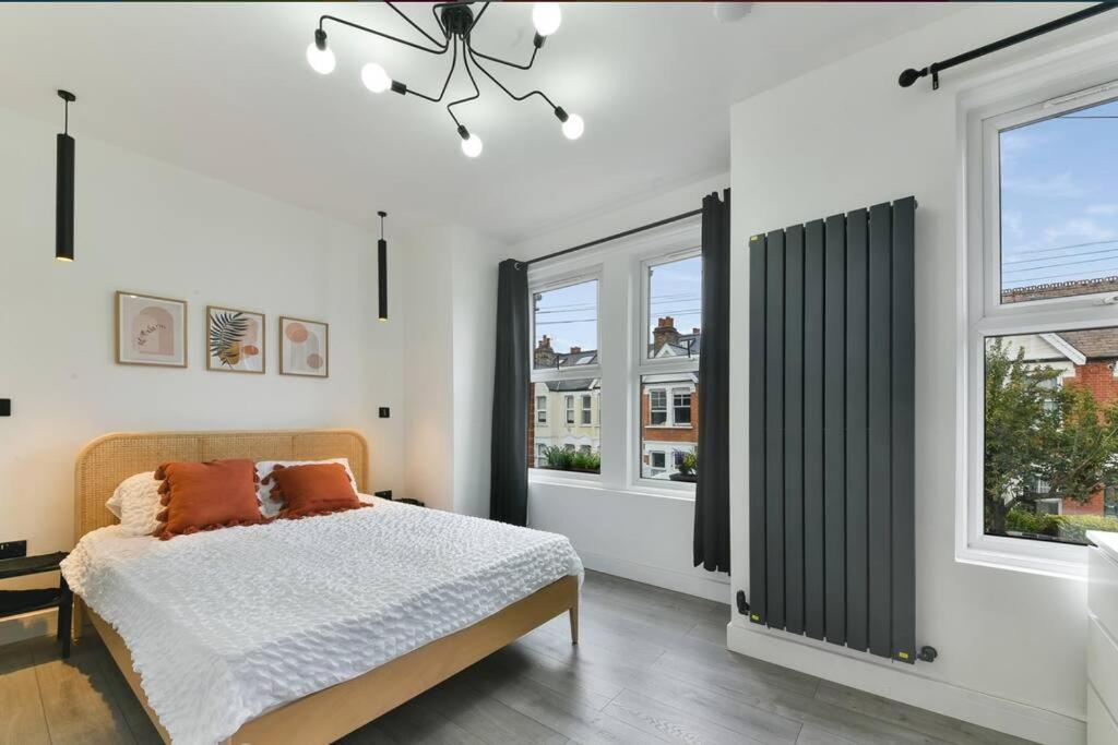 伦敦London 2-Bedrooms Apartment的一间卧室设有一张床和两个窗户。