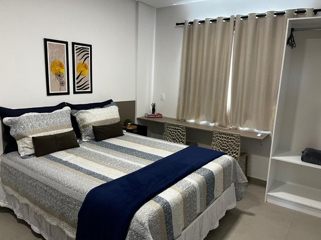 莫索罗Studio no West Fit Mossoró Alto Padrão的一间卧室配有一张带蓝白色毯子的床