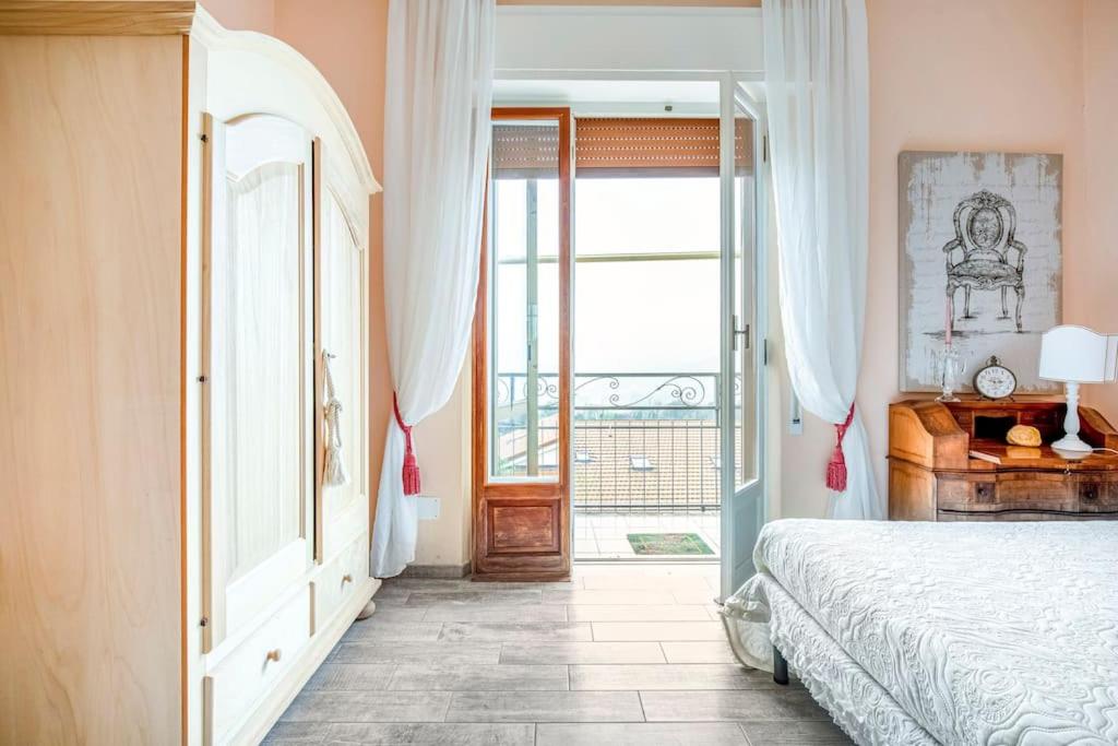 斯培西亚Annali Casa vacanze - Shabby style nella natura的一间卧室设有一张床,并有通往阳台的门