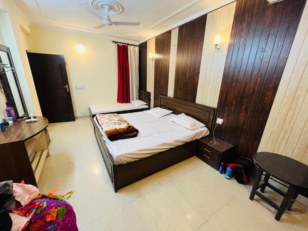 奈尼塔尔RajMahal Nainital的卧室配有1张床、1张桌子和1把椅子