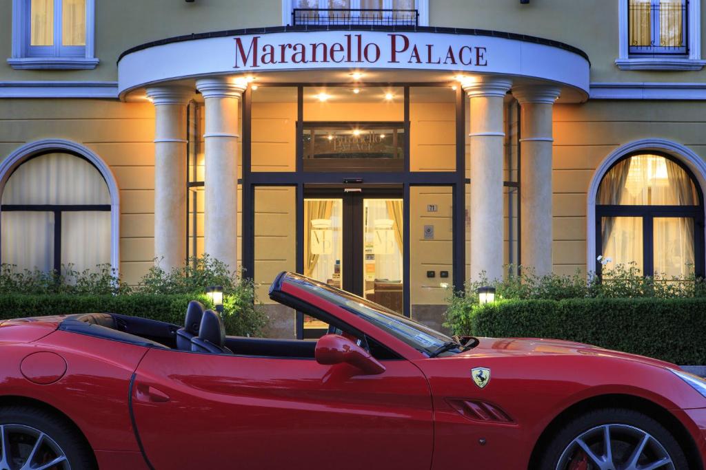 马拉内罗马拉内罗宫酒店的停在大楼前的红色汽车