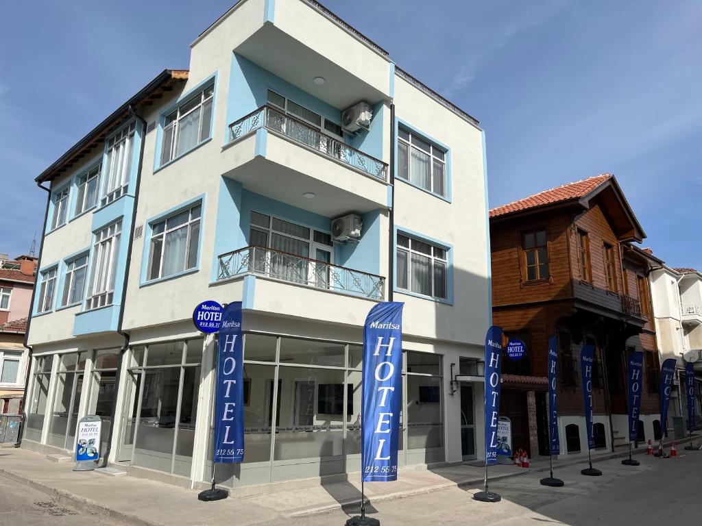 埃迪尔内Maritsa Hotel的蓝色和白色的建筑,前面有标志