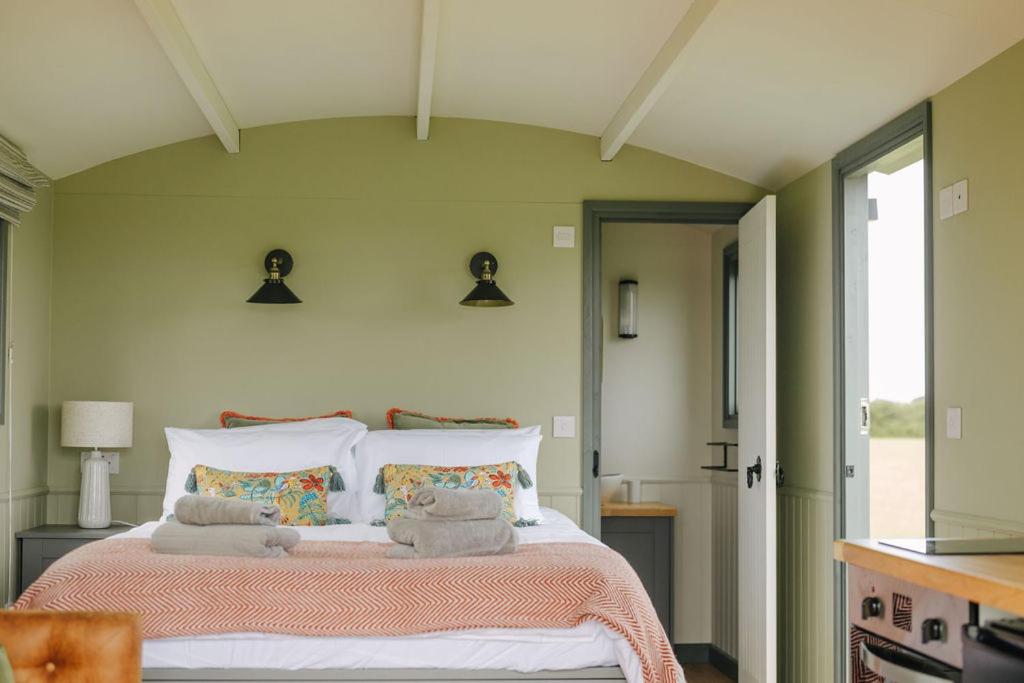 斯内蒂瑟姆Clover Hut - Snettisham Meadows的一间卧室配有一张大床和毛巾
