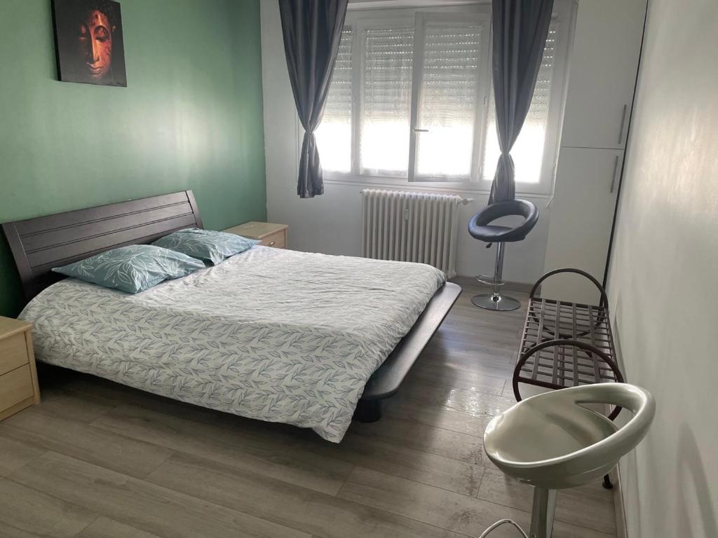 尼斯Nice appartement Avenue des Fleurs的卧室配有床、椅子和窗户。