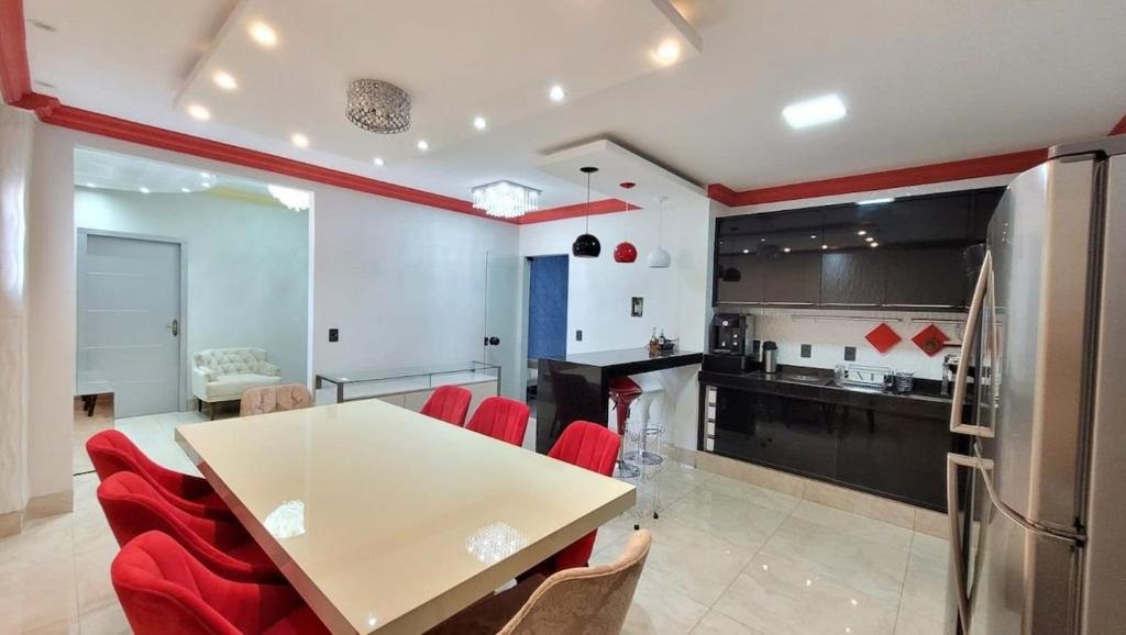 帕尔马斯Espetacular apartamento no centro的厨房配有白色的桌子和红色的椅子