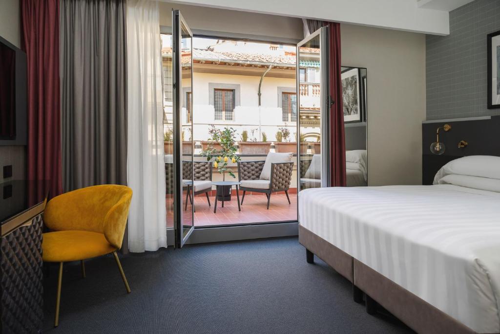 佛罗伦萨iQ Hotel Firenze的酒店客房设有一张床和一个阳台。