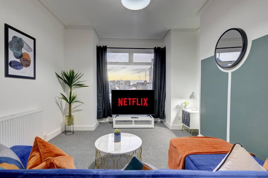 赫尔Stunning 3 bed House in Central Hull的客厅配有蓝色的沙发和电视