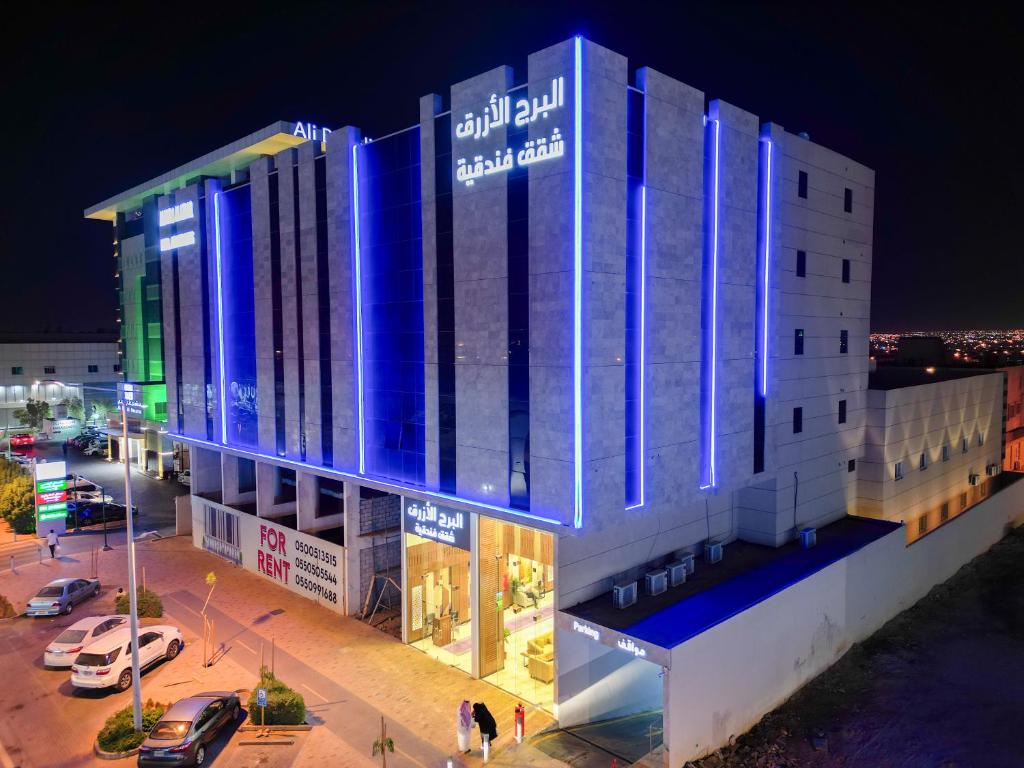 利雅德البرج الازرق شقق فندقية Alburj Alazraq的一座晚上有蓝色灯光的建筑