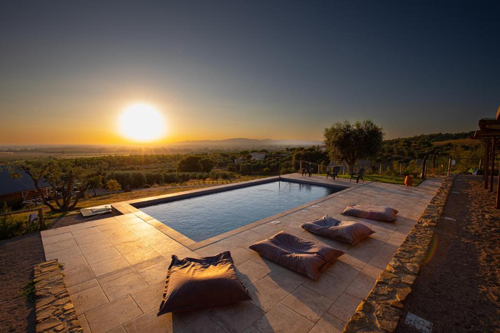 格罗塞托Glamping Grancia的一个带枕头的游泳池,享有日落美景