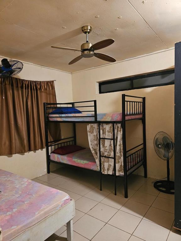 波拉波拉Raihei Auberge de jeunesse Chez l'habitant à Bora Bora的带吊扇的客房内的两张双层床