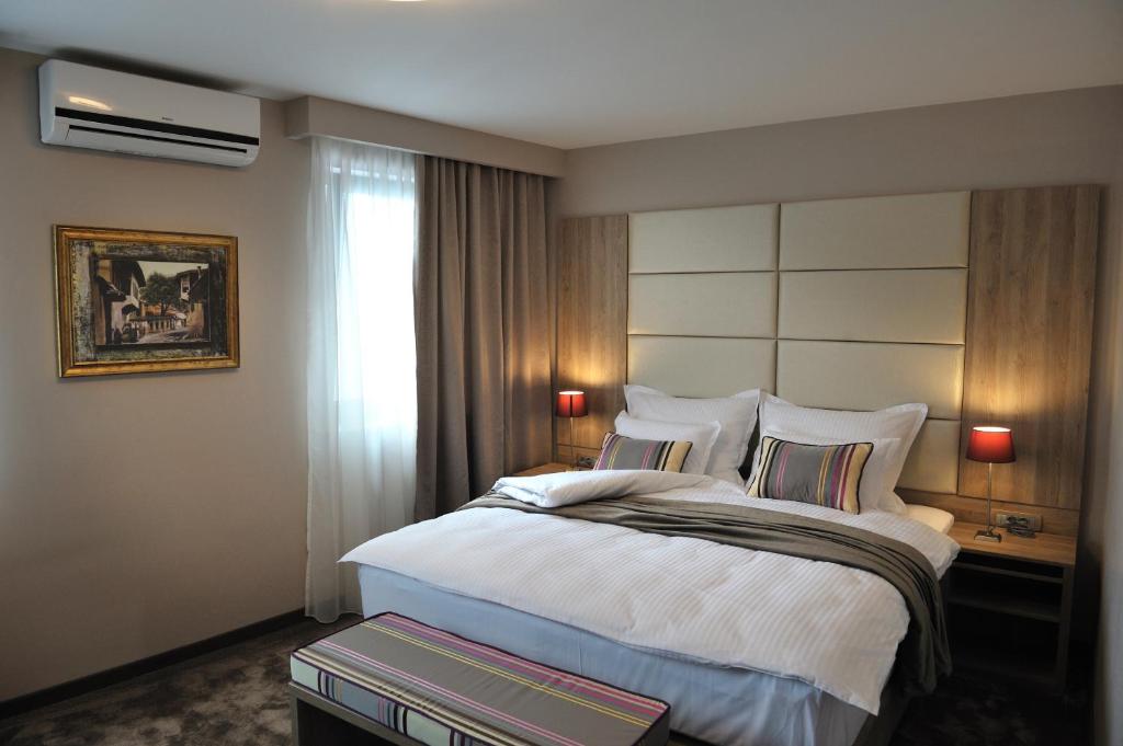 萨拉热窝贵宾酒店的一间设有大床和窗户的酒店客房