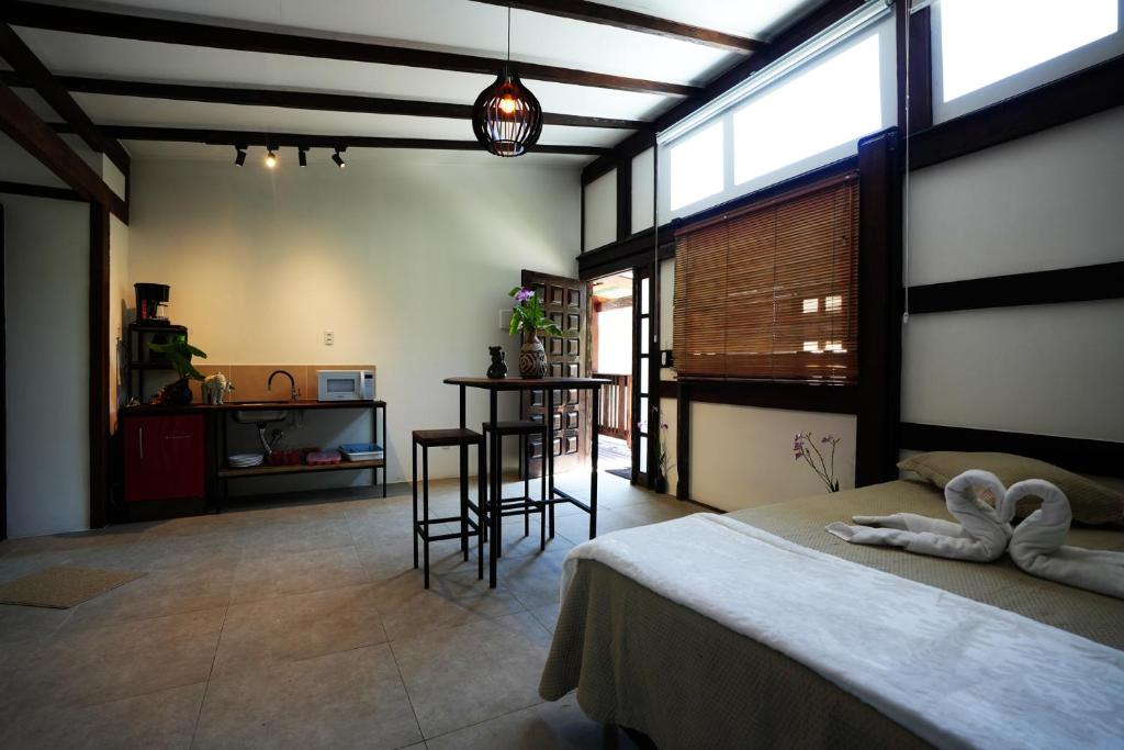 邦比尼亚斯Pousada Aquarela de Bombinhas的卧室配有一张床和一张桌子及椅子