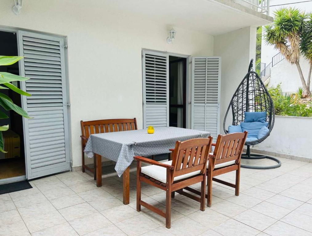 耶尔萨Apartment in Green area near the beaches的天井配有桌椅和秋千。