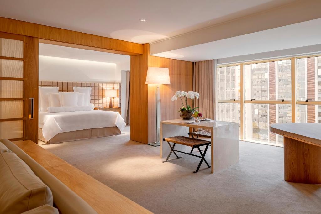 圣保罗埃米利亚诺酒店的酒店客房带一张床、一张桌子、一张床和窗户。