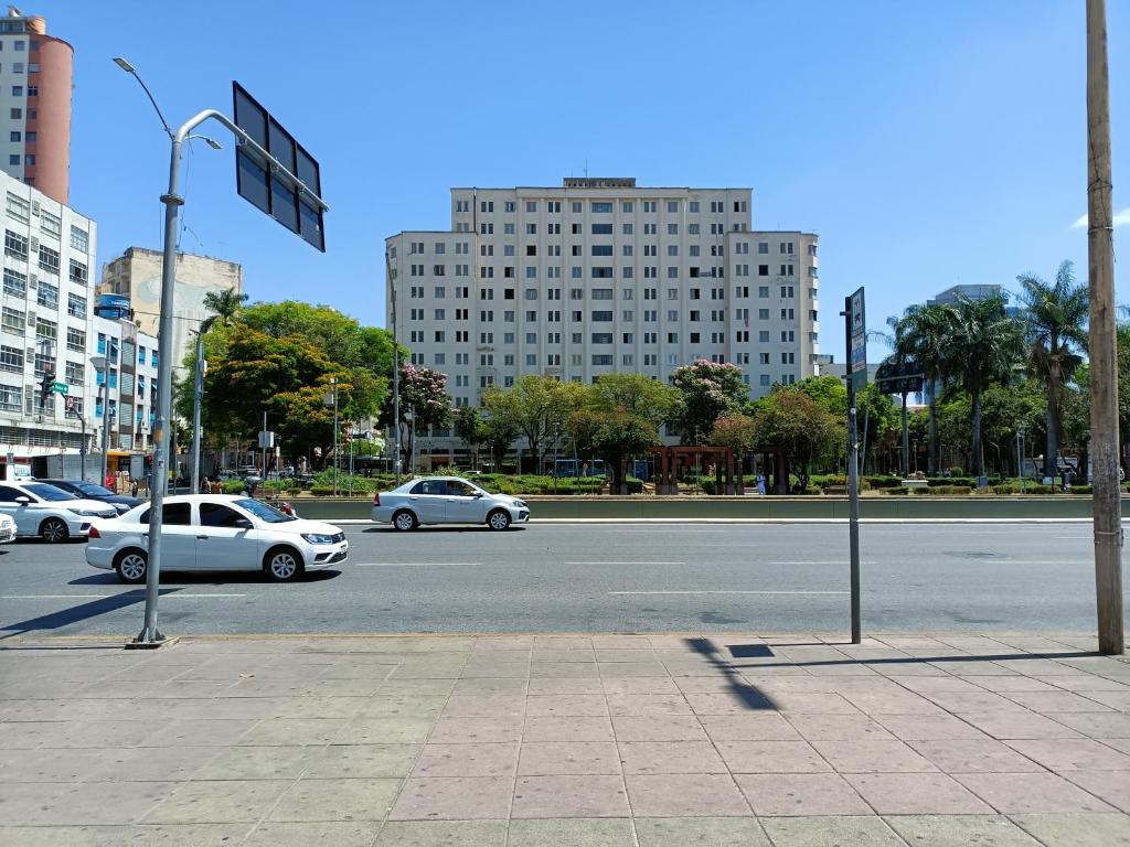 贝洛奥里藏特Apartamento Centro Belo Horizonte的一条街道,有汽车沿着街道行驶,街道上有许多建筑