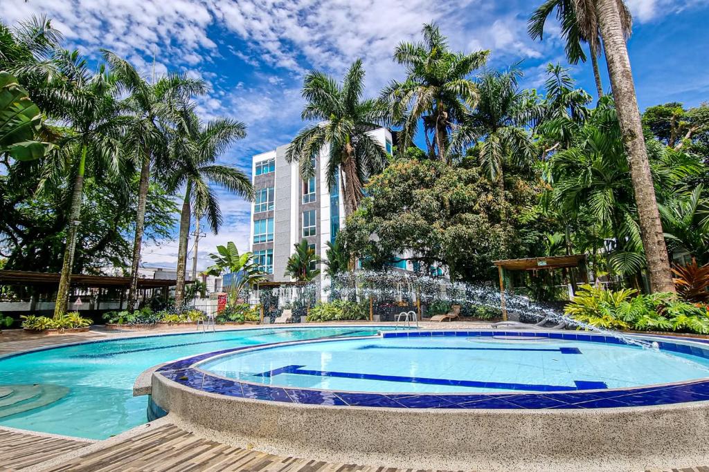 阿卡西亚斯Hotel Wayra Club的一座大楼前的游泳池,带喷泉