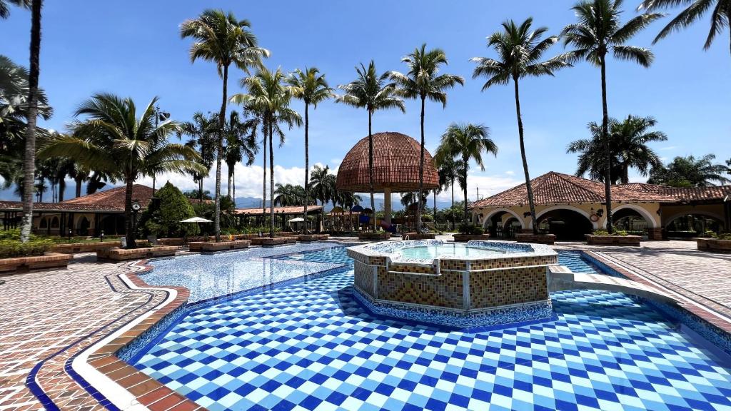 比亚维森西奥Tequendama Hotel Campestre Villavicencio的棕榈树环绕的度假村游泳池