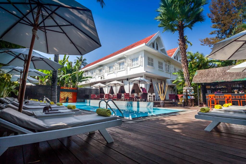 琅勃拉邦Angsana Maison Souvannaphoum Hotel的一个带游泳池和大楼的度假胜地