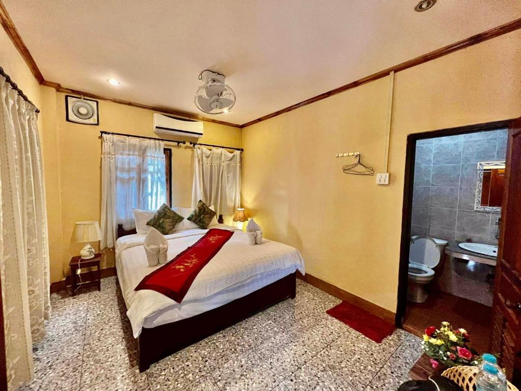 琅勃拉邦Luang Prabang Rosie Place的一间带大床的卧室和一间浴室