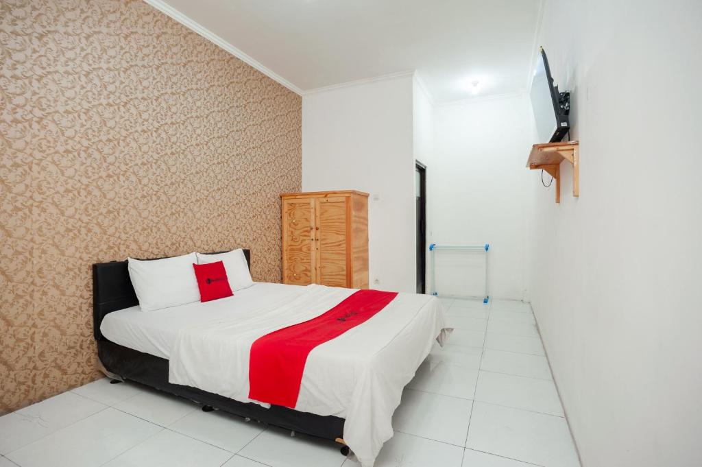 贝克西RedDoorz Syariah near Jatisampurna Hospital的一间卧室配有一张带红白毯子的床