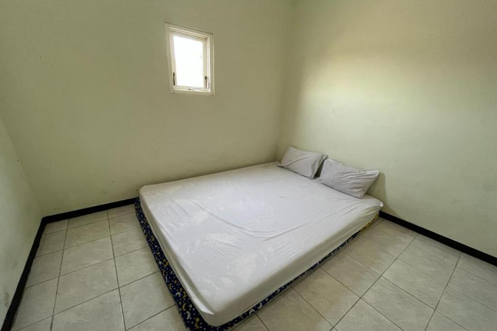 拉旺OYO Life 92982 Kost Berkah Ibu的窗户客房内的一张白色床